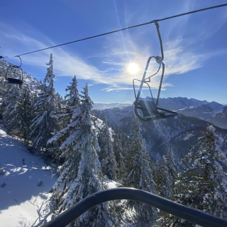 Ausblick aus dem Sessellift im Skigebiet Hochkössen auf den verschneiten Wilden Kaiser.