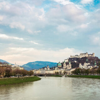 Aussicht auf die Festung Hohensalzburg mit dem Fluss Salzach im Vordergrund.