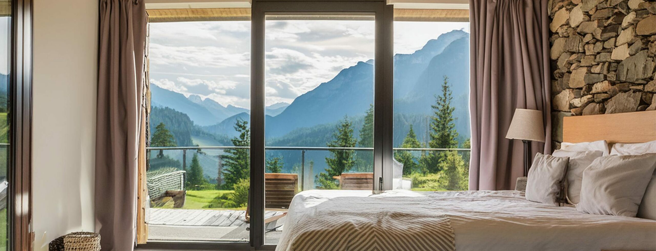 Aussicht aus einem Schlafzimmer auf die Tiroler Berglandschaft.