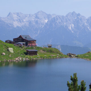 Blick vom Wildseeloder auf den Wildseelodersee und das Wildseeloderhaus in Fieberbrunn. Im Hintergrund ist der Wilde Kaiser zu erkennen.